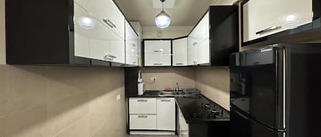 Departamento básico, balcón, vista a la ciudad | Cocina privada | Refrigerador con congelador, parrilla de estufa y tetera eléctrica
