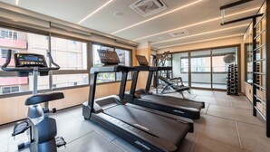 Ein modernes Fitnessstudio mit Laufbändern, Ergometer und Rudergerät.