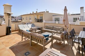 A rooftop terrace with outdoor furniture, a table, and a trash bin. - Apartment 'Penthouse with Private Pool' with Mountain View, Wi-Fi and Air Conditioning (Nerja)
