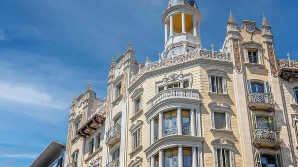 A historic building with ornate architectural details, including a dome and decorative balconies.