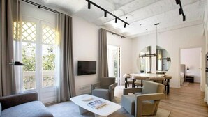 A modern living room with a sofa, coffee table, and dining area.