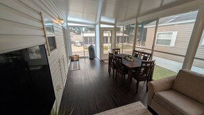 A modern kitchen with a large island, wooden flooring, and a dining area with a table and chairs. - Cozy 1-bedroom resort home with 1 bathroom. Sleeps 6 using sofa beds (Sarasota)