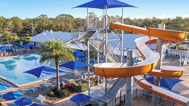 A water park with a pool, slides, umbrellas, and lounge chairs. - Cozy 1-bedroom resort home with 1 bathroom. Sleeps 6 using sofa beds (Sarasota)
