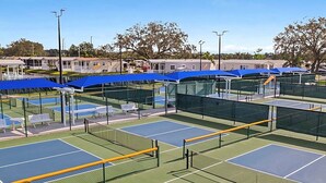 A tennis court complex with multiple courts, covered seating areas, and a clear sky. - Cozy 1-bedroom resort home with 1 bathroom. Sleeps 6 using sofa beds (Sarasota)