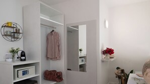 Een moderne badkamer met een witte wastafel, een spiegel, een handdoekrek en een koffieapparaat.