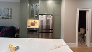 A modern kitchen with a marble countertop, built-in appliances, and a painting on the wall. - 
World Cup Toronto Stay | Stylish 2BR in Roncesvalles/Easy Transit BMO/Yard/BBQ (Toronto)