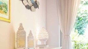 A room with a white cabinet, a decorative vase with lemons, and wall art. - CefalHome - MAGARA (Sicilia)