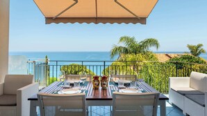A dining area with a table set for two, overlooking a scenic ocean view. - CefalHome - MAGARA (Sicilia)