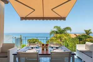 A dining area with a table set for two, overlooking a coastal view. - CefalHome - Magarà (Sicilia)