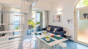 A modern living room with a sofa, dining table, and a view of the sea. - CefalHome - MAGARA (Sicilia)