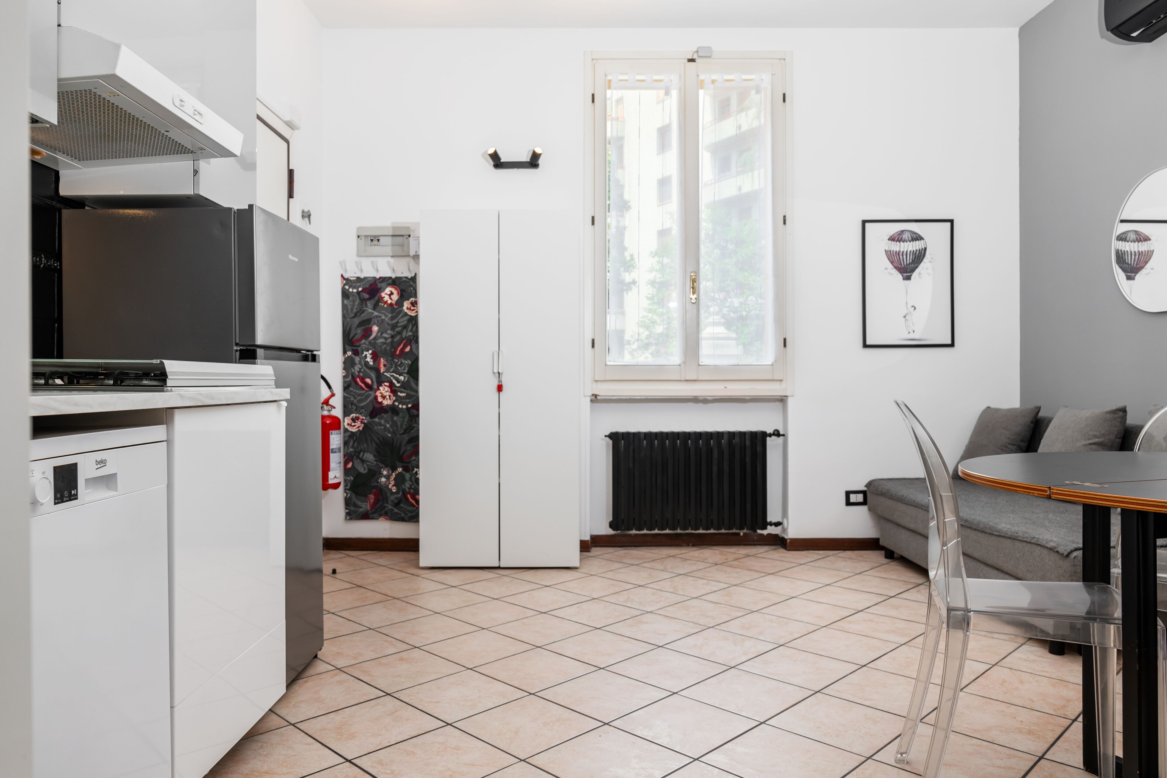 Une cuisine compacte équipée d’un réfrigérateur, d’une cuisinière et d’un coin repas avec une table et des chaises.
