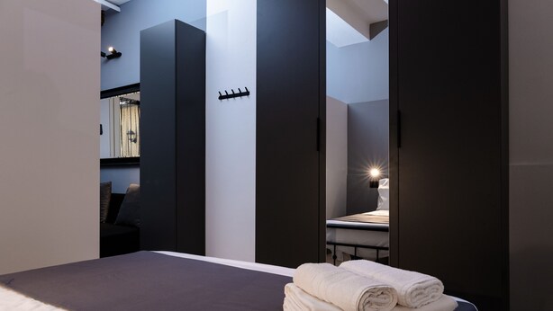 Een moderne hotelkamer met een bed, een nachtkastje en uitzicht op een badkamer.