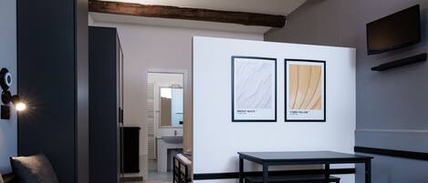 A modern room with a dark sofa, a small table, and two framed pictures on the wall.