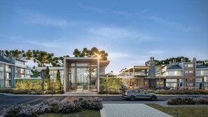 A modern residential building with a glass entrance, surrounded by well-maintained gardens and a parked car. - Veneto Residential / 2 Suites / 8 PAX / By HOUSINGCEARA (Gramado)