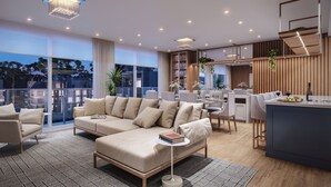 A modern living room with a sofa, chairs, a small table, and a kitchen area with a bar. - Veneto Residential / 2 Suites / 8 PAX / By HOUSINGCEARA (Gramado)