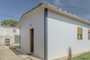 Un bâtiment moderne doté d’un toit plat, d’une porte et de fenêtres.