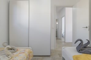 A hotel room with a bed, a wardrobe, and a hallway leading to another room. - Holiday Home 'Sofia' with Private Pool, Wi-Fi and Air Conditioning (Conil de la Frontera)