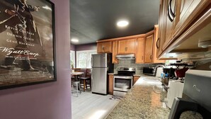 A modern kitchen with granite countertops, stainless steel appliances, and wooden cabinets. - Movie Magic: The Scene-Stealer (Winston-Salem)