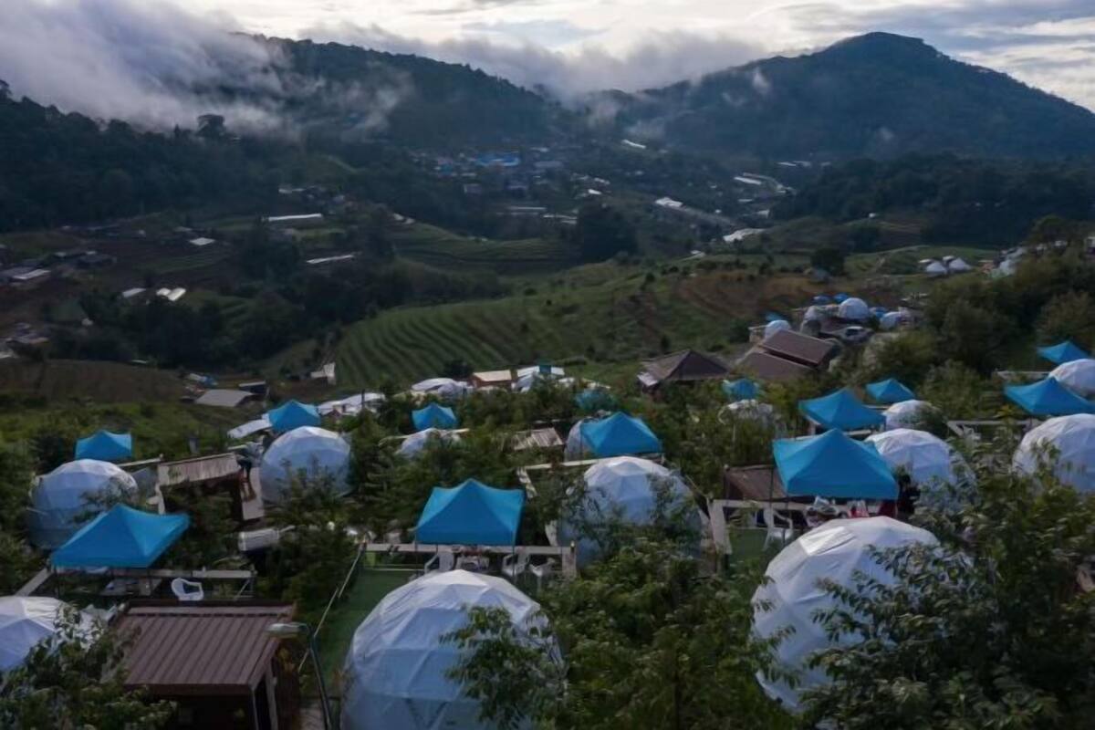 A rural landscape with spherical structures and traditional buildings.