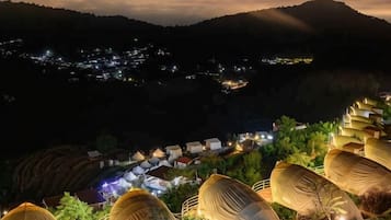 Ein Dorf mit terrassenförmig angelegten Feldern und Häusern in der Nacht.