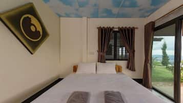 A hotel room with a bed, curtains, a window, and a view of the outdoors.
