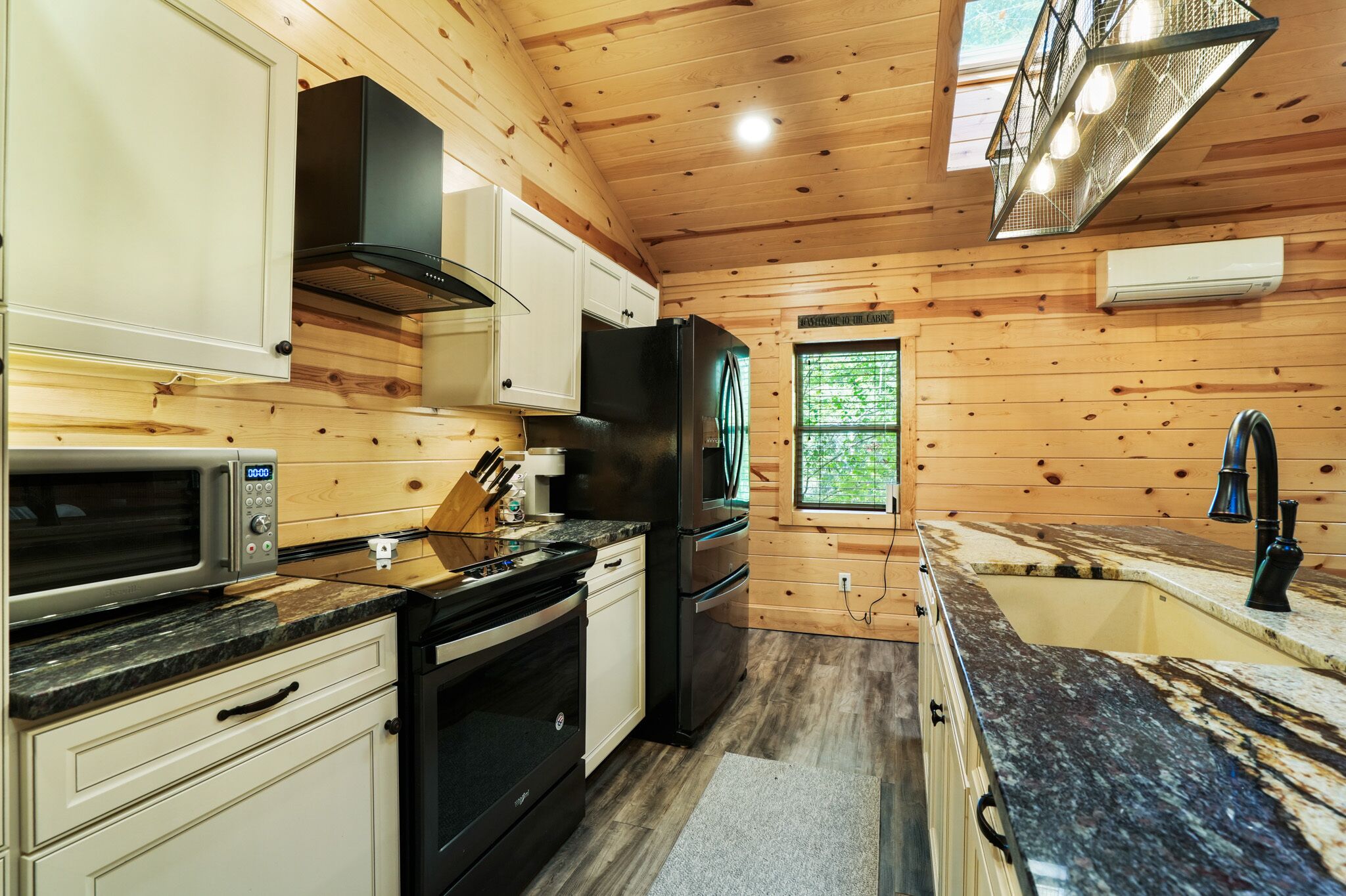 A compact kitchen with a microwave, stove, oven, and refrigerator.