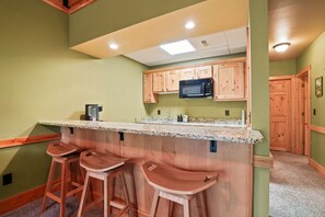 A kitchen with wooden cabinets, a granite countertop, and a built-in microwave.