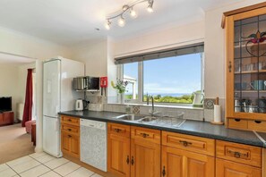 Una cocina moderna con lavavajillas incorporado, microondas y un amplio ventanal con vistas al exterior.