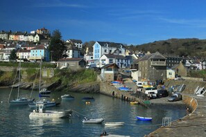 A coastal town with a harbor filled with boats, houses with colorful facades, and a clear blue sky. - Tydu View Cottage, New Quay (Llangrannog)