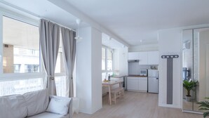 Un appartement moderne comprenant un espace de vie, une kitchenette et un coin repas.