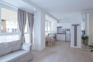 Un appartamento moderno con zona soggiorno, angolo cottura e zona pranzo.