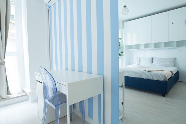 Un dormitorio con cama, escritorio y silla.