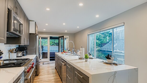 A modern kitchen with stainless steel appliances, a marble countertop, and a view of the outdoors. - Old Town Park City Luxury with Private Spa and Views 440 (Park City)