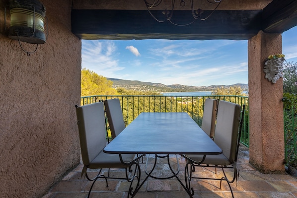 Un espacio de descanso al aire libre cubierto con una mesa y sillas, con vistas a un paisaje pintoresco.