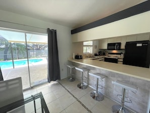 Fridge, microwave, oven, stovetop - Spacious 3BR/2BA Cape Coral home with pool, AC, BBQ, loungers & patio (Cape Coral)