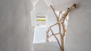 Un interior moderno con un diseño arquitectónico único, que presenta un gran ventanal y un elemento de madera natural.