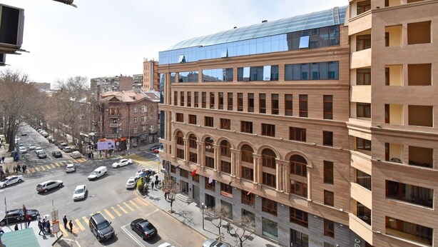 Un edificio de varios pisos con fachada moderna de vidrio y arquitectura de ladrillo tradicional.