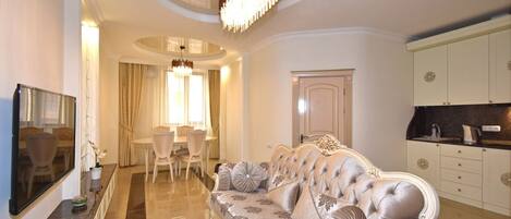 Leilighet – deluxe | Oppholdsområde | En 50-tommers Flatskjerm-TV med kabel-kanaler