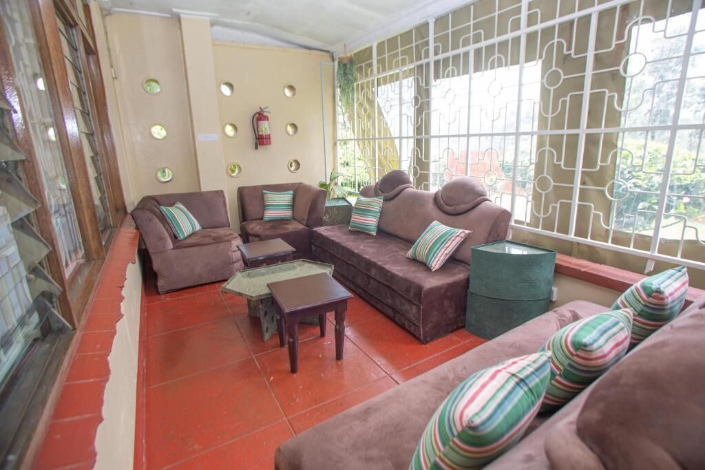 A cozy lounge area with cushioned seating, a small table, and a decorative wall with circular mirrors and a fire extinguisher.