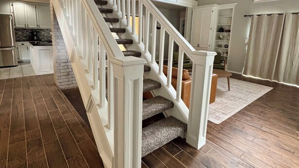 Un intérieur spacieux avec un escalier en bois, un coin cuisine et un espace repas.