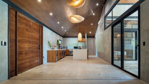 Une cuisine spacieuse dotée d’un îlot central, de meubles en bois et de luminaires suspendus.