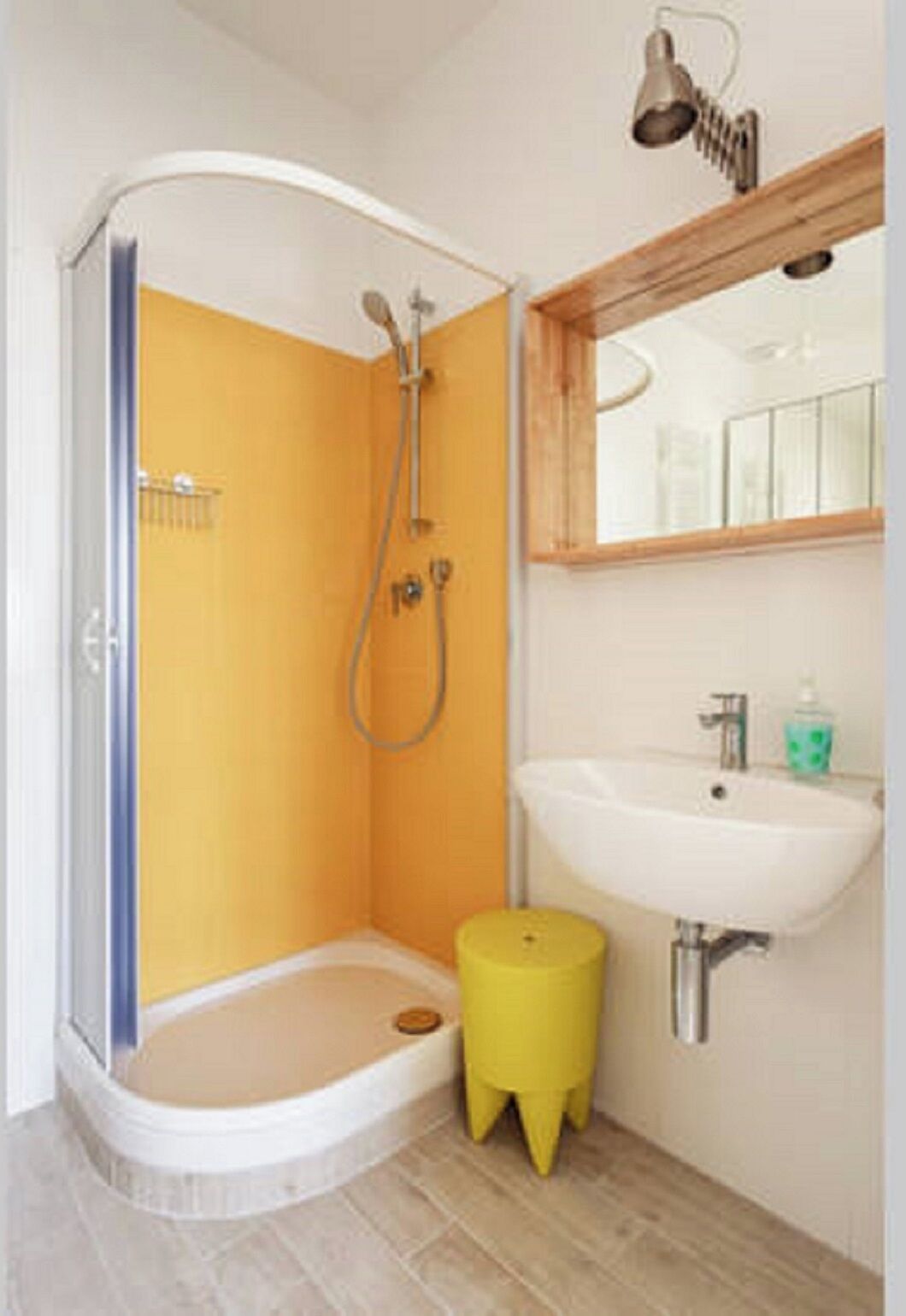 Un bagno con doccia, lavandino e specchio.