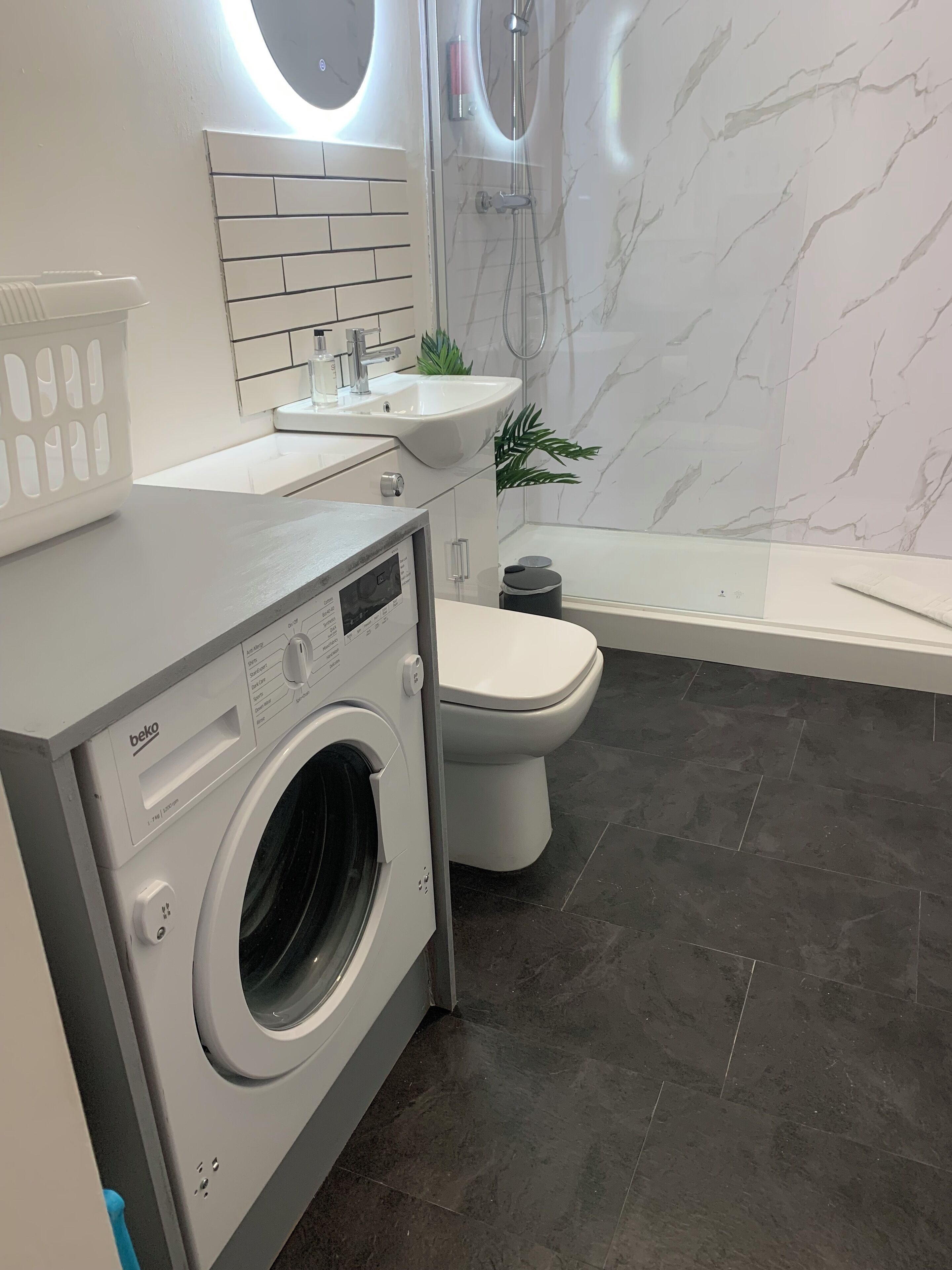 Un baño moderno con lavadora, inodoro y lavabo.