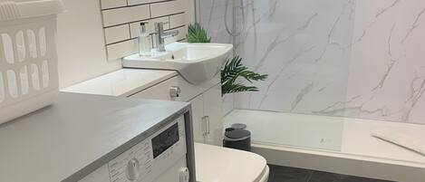 Un baño moderno con lavadora, inodoro y lavabo.
