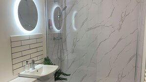 A modern bathroom with a shower, toilet, and sink. - 2 x bed city apartment with parking  (Hull)