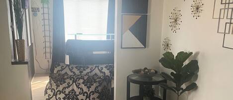 A living room with a patterned sofa, a small round table, and decorative wall art.