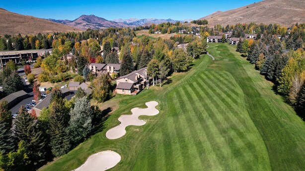 A golf course with a clubhouse, surrounded by trees and mountains. - Fairway Haven with Private hot tub! Dog Friendly! (Sun Valley)