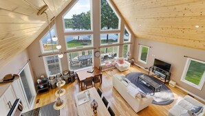 A spacious living area with large windows, a fireplace, and a cozy seating arrangement.