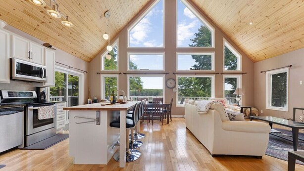 A spacious kitchen with modern appliances, a dining area with a central island, and a cozy living room with large windows.