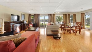 A spacious living area with a fireplace, sofa, and dining table.